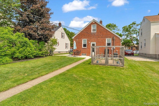 3220 John R St, Trenton, MI 48183 - back of house with a yard, brick siding, a chimney, and a patio