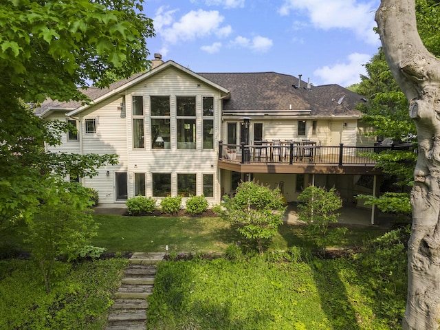 565 Hawksnest Dr, South Haven, MI 49090 - rear view of house featuring a wooden deck, a chimney, a yard, and a shingled roof