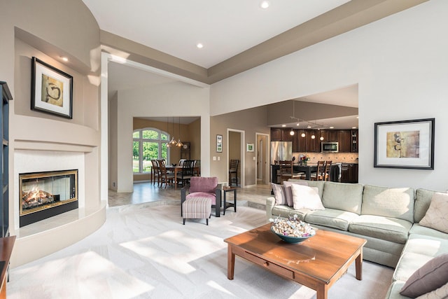565 Hawksnest Dr, South Haven, MI 49090 - living area with a chandelier, a glass covered fireplace, a towering ceiling, and recessed lighting