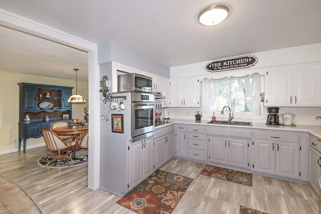 4143 Browning Dr, Saint Joseph, MI 49085 - kitchen featuring a sink, appliances with stainless steel finishes, light wood finished floors, and light countertops