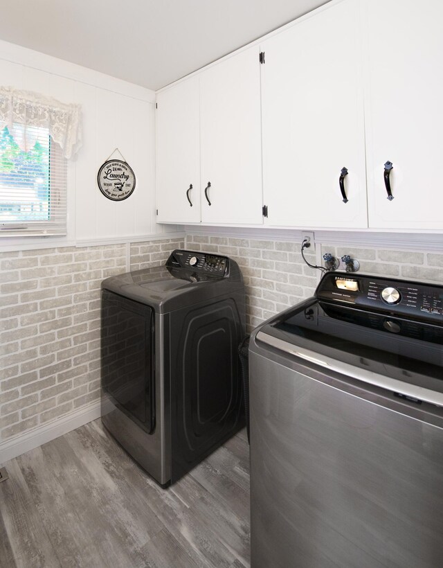 4143 Browning Dr, Saint Joseph, MI 49085 - washroom featuring independent washer and dryer, wood finished floors, and cabinet space