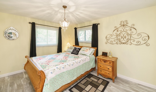 4143 Browning Dr, Saint Joseph, MI 49085 - bedroom with light wood finished floors, baseboards, and a chandelier