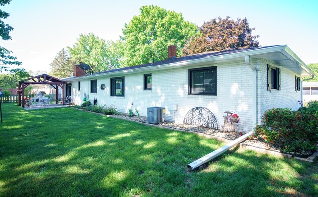 4143 Browning Dr, Saint Joseph, MI 49085 - view of side of home with a chimney, a gazebo, a lawn, brick siding, and central AC