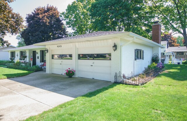 4143 Browning Dr, Saint Joseph, MI 49085 - view of front of home featuring brick siding, a chimney, driveway, and a front yard