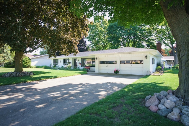 4143 Browning Dr, Saint Joseph, MI 49085 - single story home with a chimney, an attached garage, concrete driveway, and a front lawn