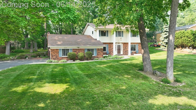 6624 Wellesley Ter, Clarkston, MI 48346 - view of front of house featuring brick siding, a front lawn, driveway, and a chimney