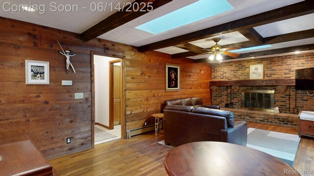 6624 Wellesley Ter, Clarkston, MI 48346 - living room with a skylight, wood finished floors, a baseboard radiator, a fireplace, and beamed ceiling