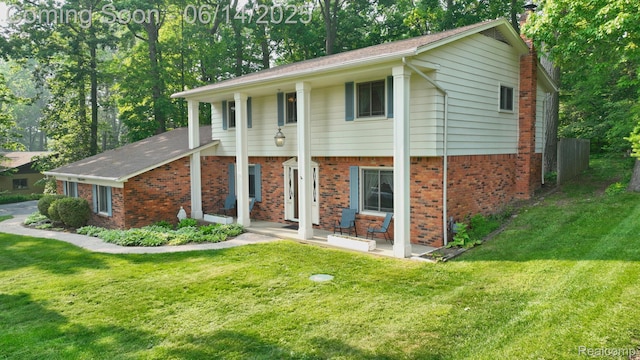 6624 Wellesley Ter, Clarkston, MI 48346 - view of front of home with brick siding, a front lawn, and a chimney