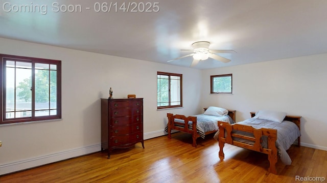 6624 Wellesley Ter, Clarkston, MI 48346 - bedroom with a baseboard heating unit, light wood-style flooring, and ceiling fan