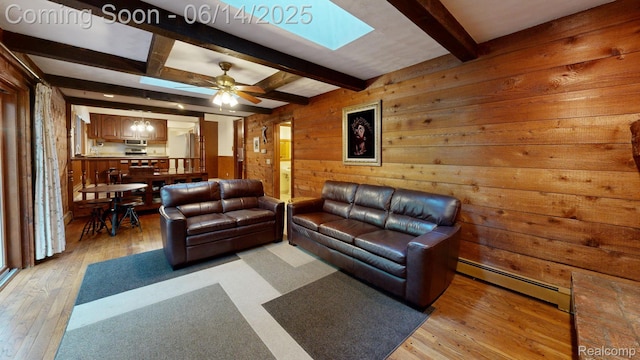 6624 Wellesley Ter, Clarkston, MI 48346 - living room with baseboard heating, wooden walls, a skylight, light wood-style floors, and beamed ceiling