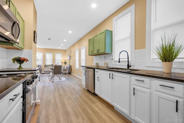 8857 Charlevoix St, Detroit, MI 48214 - kitchen with appliances with stainless steel finishes, a sink, decorative backsplash, light wood-type flooring, and recessed lighting