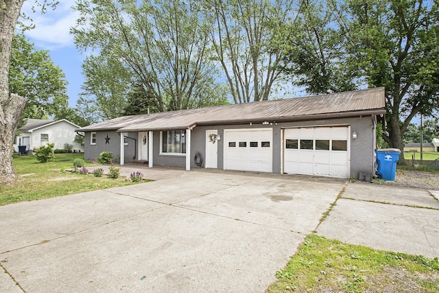 15765 Mason St, Union, MI 49130 - view of front of house with an attached garage, driveway, metal roof, and brick siding