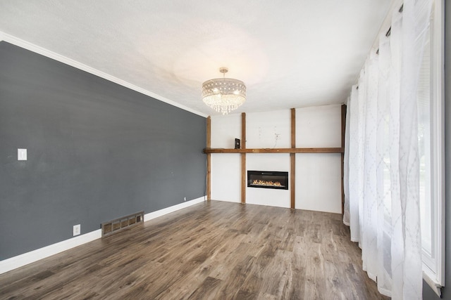 15765 Mason St, Union, MI 49130 - unfurnished living room featuring wood finished floors, a chandelier, a glass covered fireplace, crown molding, and baseboards