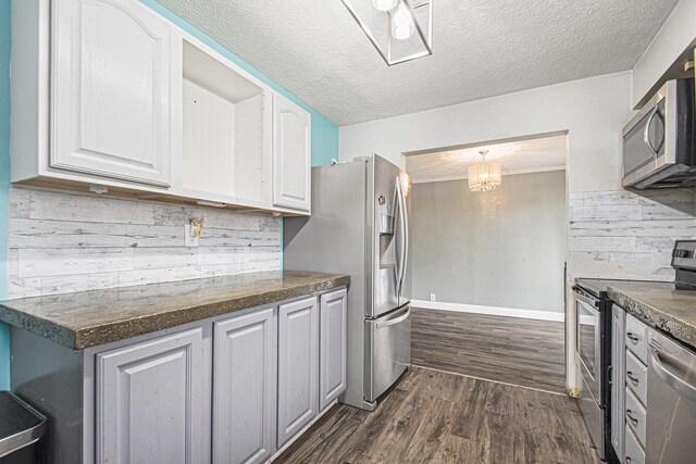 15765 Mason St, Union, MI 49130 - kitchen featuring stainless steel appliances, dark countertops, dark wood finished floors, white cabinets, and a textured ceiling
