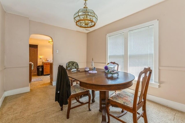 927 Harrison Ave, Saint Joseph, MI 49085 - dining room with arched walkways, light colored carpet, baseboards, and a chandelier