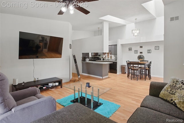 1332 Shoemaker Dr Unit 1332, Belleville, MI 48185 - living area with a ceiling fan, light wood finished floors, a chandelier, a skylight, and vaulted ceiling