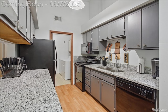 1332 Shoemaker Dr Unit 1332, Belleville, MI 48185 - kitchen with black appliances, a sink, light wood-style floors, gray cabinetry, and a towering ceiling