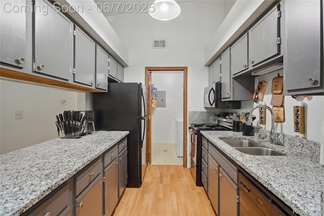 1332 Shoemaker Dr Unit 1332, Belleville, MI 48185 - kitchen with black range with electric cooktop, a sink, freestanding refrigerator, light wood-type flooring, and electric panel