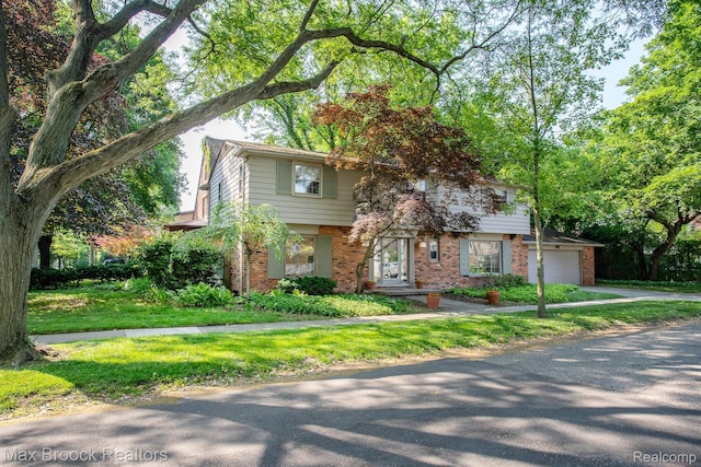 8019 Concord Rd, Huntington Woods, MI 48070 - view of front facade with brick siding, driveway, a garage, and a front yard