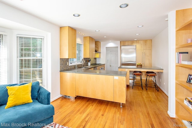 8019 Concord Rd, Huntington Woods, MI 48070 - kitchen featuring stainless steel refrigerator, a peninsula, light wood finished floors, backsplash, and recessed lighting