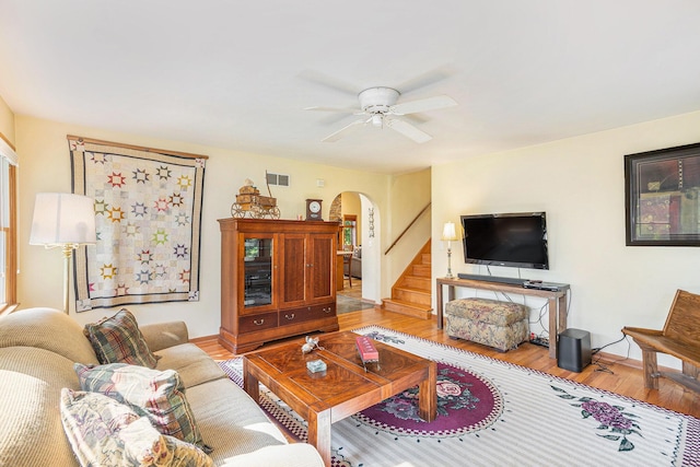 5700 Dexter Townhall Rd, Dexter, MI 48130 - living area featuring arched walkways, wood finished floors, stairs, ceiling fan, and baseboards