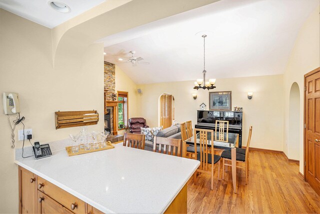 5700 Dexter Townhall Rd, Dexter, MI 48130 - kitchen with arched walkways, ceiling fan, light countertops, and high vaulted ceiling
