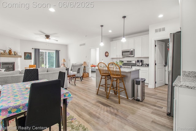 11801 Hines Place Dr, Livonia, MI 48150 - dining space with light wood-style flooring, ceiling fan, recessed lighting, and a glass covered fireplace