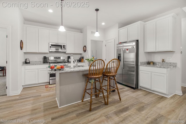 11801 Hines Place Dr, Livonia, MI 48150 - kitchen with stainless steel appliances, light wood finished floors, a kitchen breakfast bar, a sink, and recessed lighting