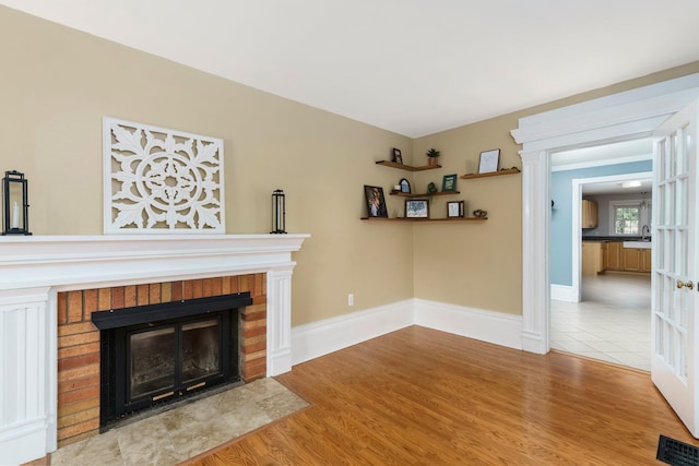 46860 Shelby Rd, Michigan, MI 48317 - unfurnished living room featuring a fireplace, a sink, light wood finished floors, and baseboards