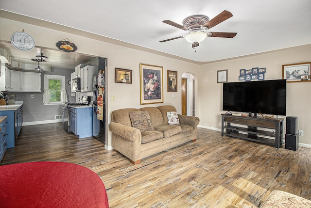 130 Woodway Ave, Battle Creek, MI 49014 - living room featuring arched walkways, wood finished floors, ceiling fan, and baseboards