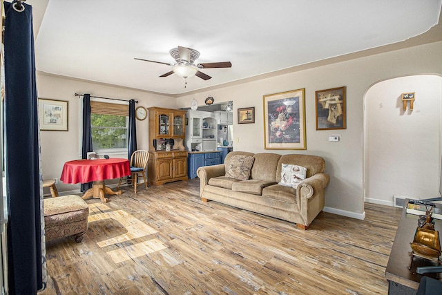 130 Woodway Ave, Battle Creek, MI 49014 - living room featuring a ceiling fan, light wood-style flooring, arched walkways, and baseboards
