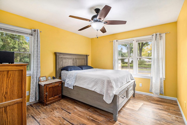 130 Woodway Ave, Battle Creek, MI 49014 - bedroom featuring multiple windows, light wood-type flooring, a ceiling fan, and baseboards