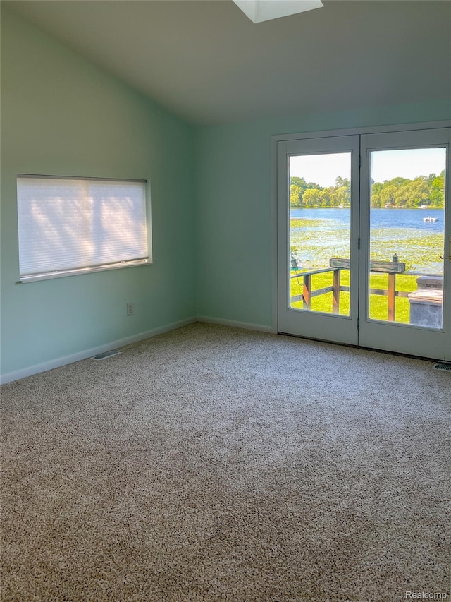 1749 Tannock Dr, Holly, MI 48442 - carpeted empty room with lofted ceiling, a water view, and a skylight