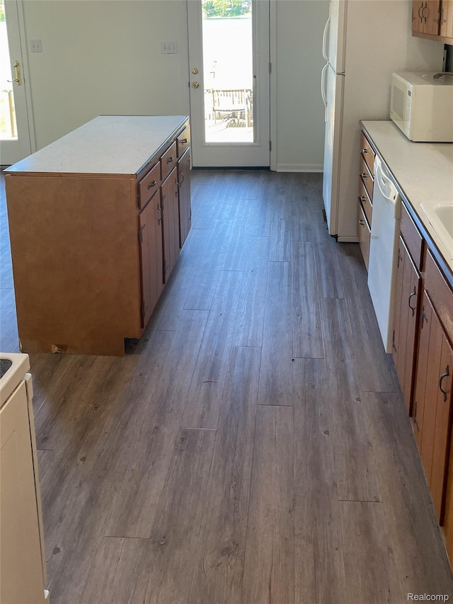 1749 Tannock Dr, Holly, MI 48442 - kitchen with white appliances, wood finished floors, light countertops, and a center island
