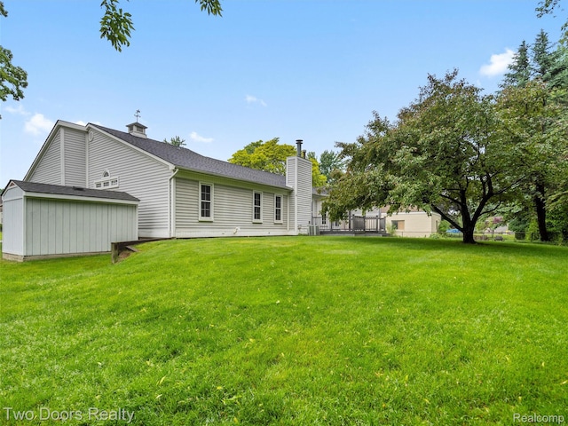 53020 Wolf Dr, Shelby Twp, MI 48316 - back of property featuring a chimney, a lawn, and an outdoor structure