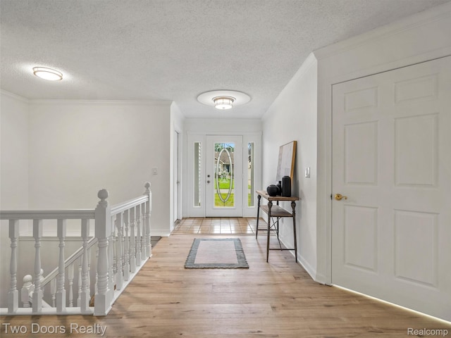 53020 Wolf Dr, Shelby Twp, MI 48316 - entrance foyer with wood finished floors, a textured ceiling, ornamental molding, and baseboards