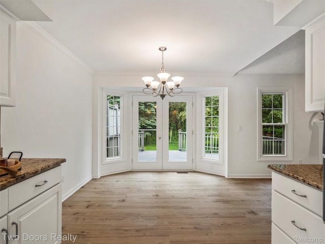 53020 Wolf Dr, Shelby Twp, MI 48316 - unfurnished dining area with light wood-type flooring, a chandelier, baseboards, and crown molding