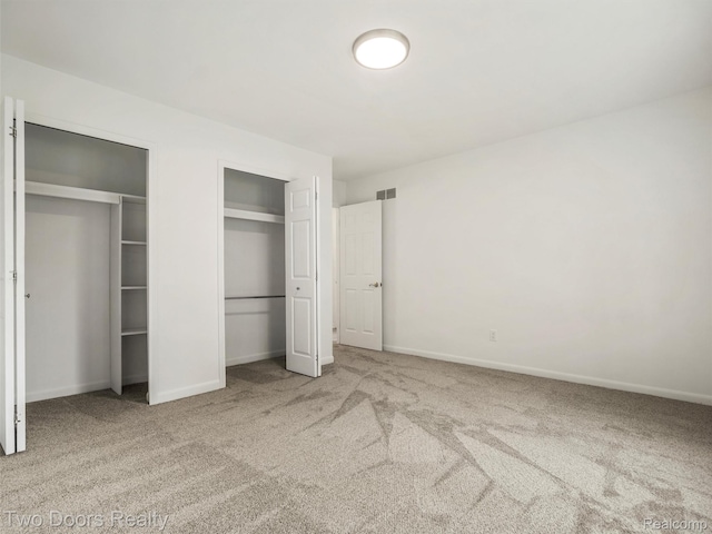 53020 Wolf Dr, Shelby Twp, MI 48316 - unfurnished bedroom with multiple closets, carpet flooring, and baseboards
