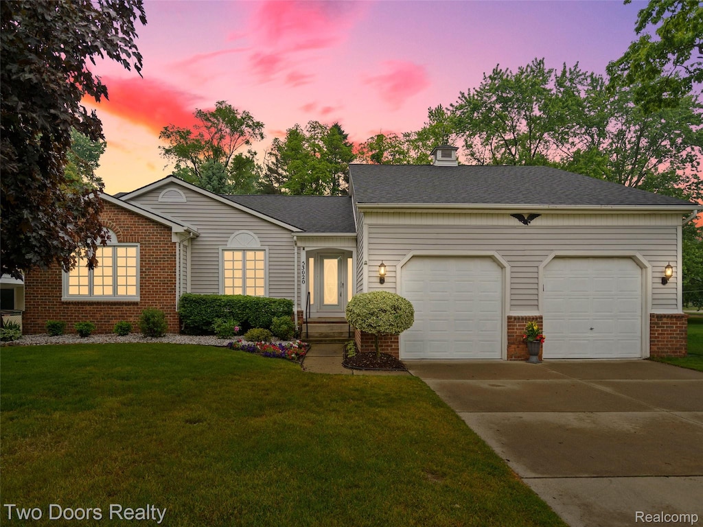 53020 Wolf Dr, Shelby Twp, MI 48316 - view of front facade featuring brick siding, a garage, driveway, and a front yard