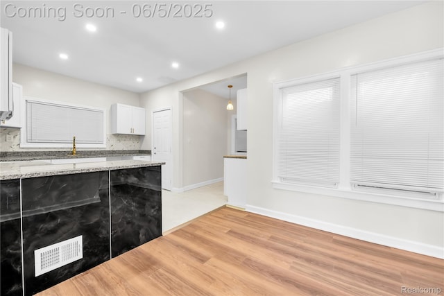 14953 Winthrop St, Detroit, MI 48227 - kitchen with light wood-style floors, white cabinets, decorative backsplash, light stone countertops, and recessed lighting