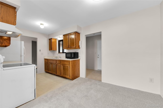 11919 Ina Dr, Sterling Heights, MI 48312 - kitchen with black microwave, stove, freestanding refrigerator, washer / dryer, and brown cabinetry