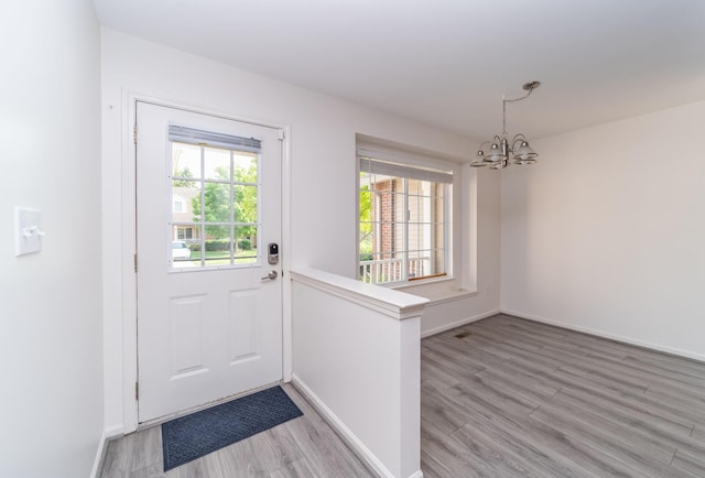 392 Woodfield Square Ln, Brighton, MI 48116 - doorway with a chandelier, light wood-type flooring, and baseboards