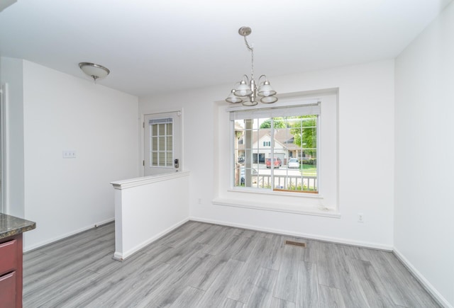 392 Woodfield Square Ln, Brighton, MI 48116 - unfurnished dining area featuring a chandelier, light wood-style floors, and baseboards