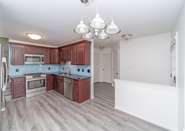 392 Woodfield Square Ln, Brighton, MI 48116 - kitchen featuring appliances with stainless steel finishes, a sink, a chandelier, and tasteful backsplash