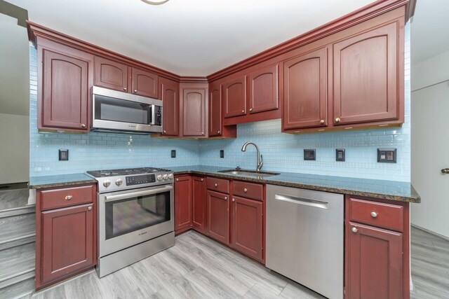 392 Woodfield Square Ln, Brighton, MI 48116 - kitchen with appliances with stainless steel finishes, a sink, dark stone countertops, and tasteful backsplash