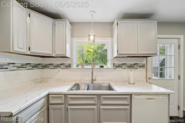 8921 Lake Rd, Grosse Ile, MI 48138 - kitchen featuring white dishwasher, a sink, backsplash, decorative light fixtures, and plenty of natural light