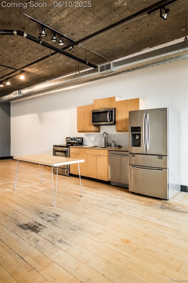 460 W Canfield Street Loft 207/ Unit 16, Detroit, MI 48201 - kitchen with stainless steel appliances, track lighting, tasteful backsplash, light wood-style flooring, and a sink