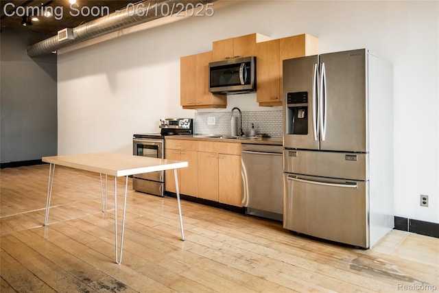 460 W Canfield Street Loft 207/ Unit 16, Detroit, MI 48201 - kitchen with appliances with stainless steel finishes, light wood finished floors, tasteful backsplash, and a sink