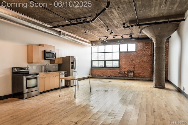 460 W Canfield Street Loft 207/ Unit 16, Detroit, MI 48201 - kitchen with stainless steel appliances, brick wall, light wood finished floors, light brown cabinetry, and rail lighting