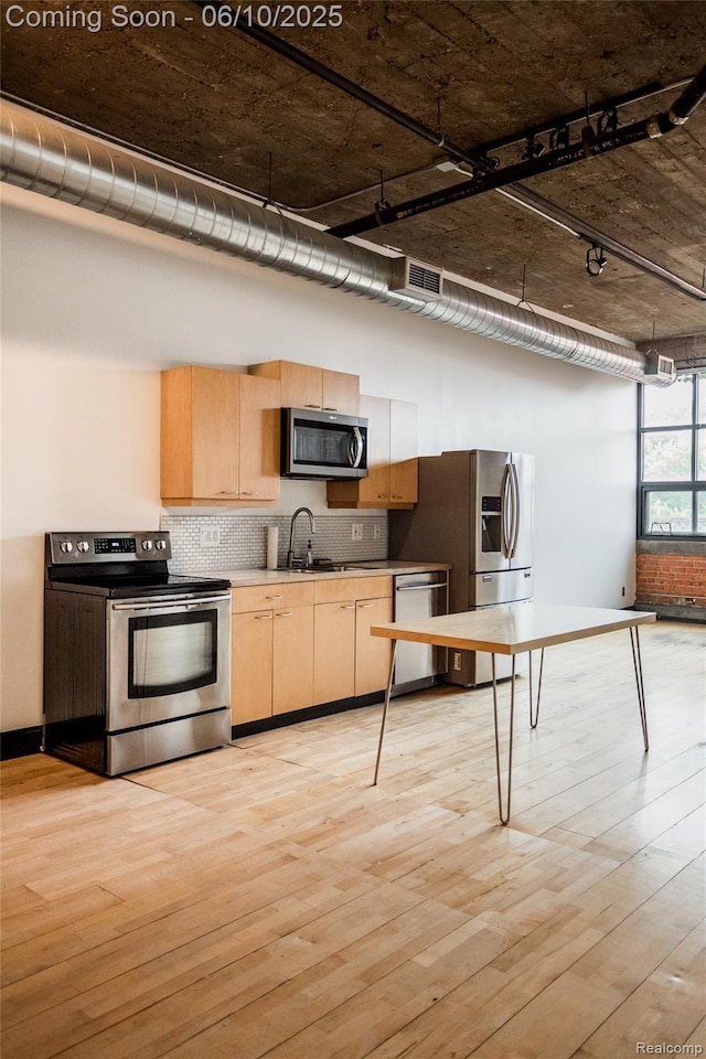 460 W Canfield Street Loft 207/ Unit 16, Detroit, MI 48201 - kitchen featuring stainless steel appliances, light brown cabinetry, backsplash, light wood finished floors, and a high ceiling